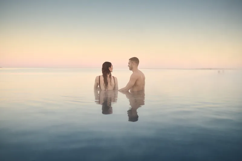 A couple in the Sky Lagoon at sunset