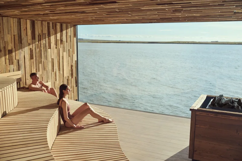 A guest relaxing on the Sky Lagoon deck looking out to sea