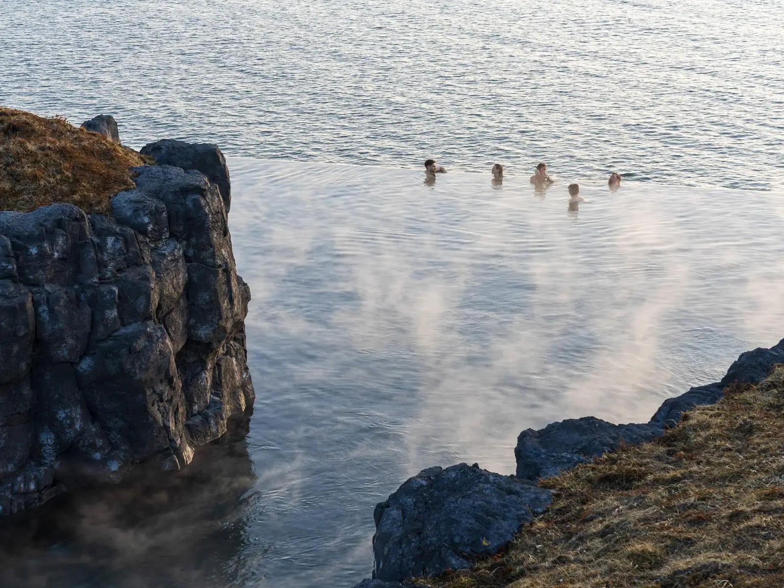 Bathers at the Sky Lagoon infinity edge with the North Atlantic beyond