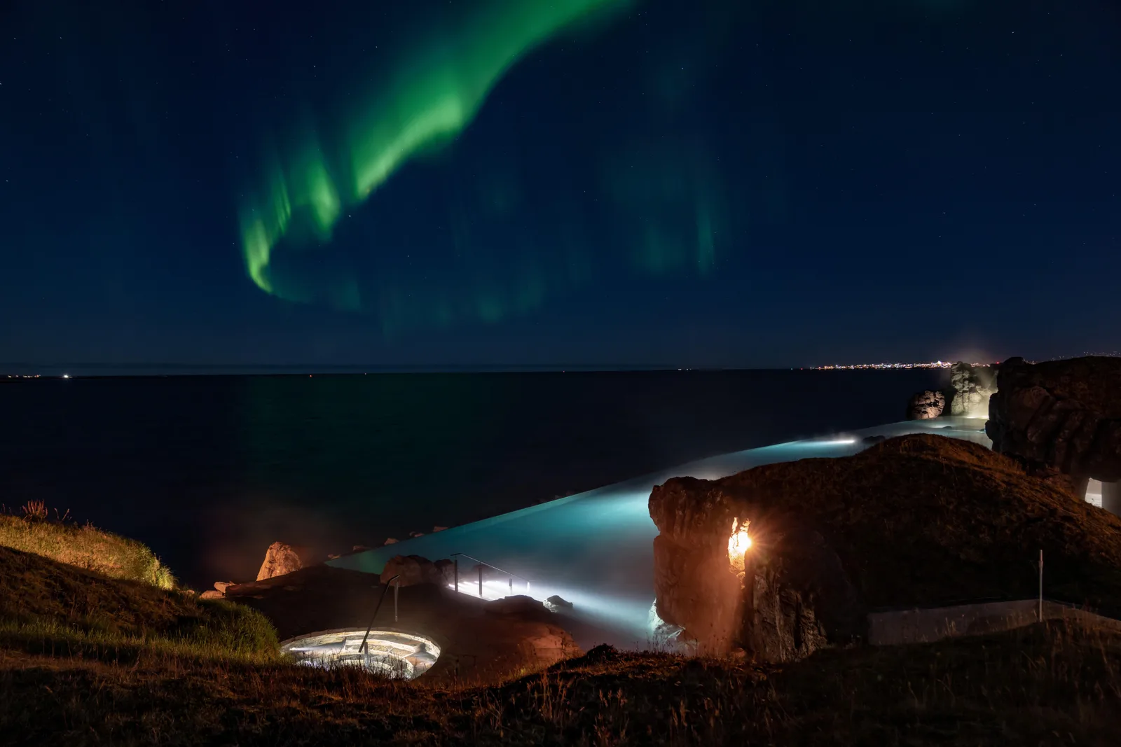 Northern lights glowing over the Sky Lagoon geothermal spa in Iceland